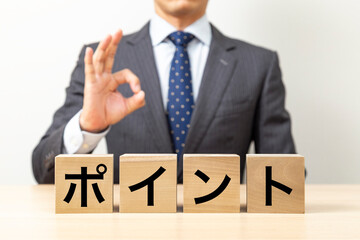 「ポイント」と書かれたブロックとOKポーズをするビジネスマン