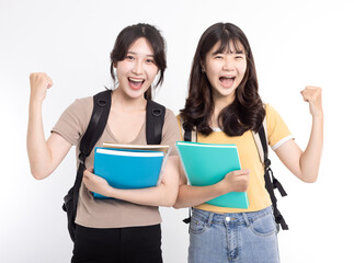 Two happy asian female students carrying notebooks and backpack