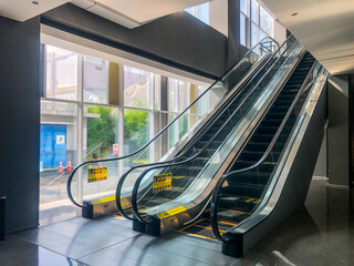 A modern building with two escalator. The building has multiple floors. Modern building Escalator, Sleek and Contemporary Building Design. hotel. industrial, urban. 
