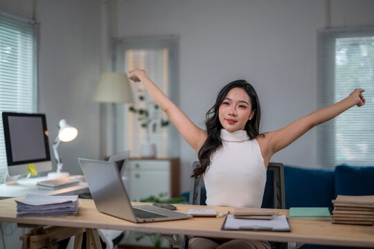Asian freelancer woman stretching while working from home office