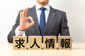 「求人情報」と書かれたブロックとOKポーズをするビジネスマン