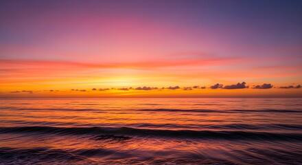 Obraz premium Vivid sunset over the ocean with colorful sky and gentle waves sea clouds