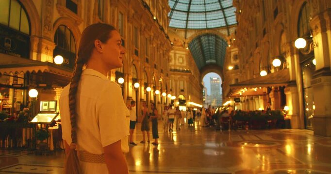 Woman exploring Galleria Vittorio Emanuele II in the evening