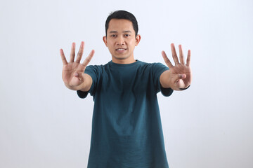 Asian man showing nine fingers. Hand gesture for the number 9. Isolated portrait.