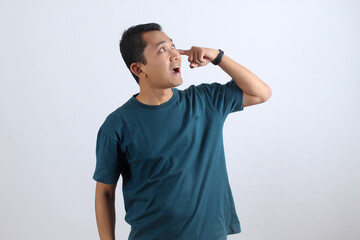 Funny Asian man has a eureka moment, pointing to his eye with a creative idea
