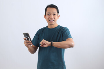 Smiling Asian man using smartwatch and smartphone technology
