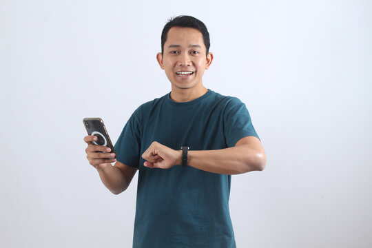 Smiling Asian man using smartwatch and smartphone technology