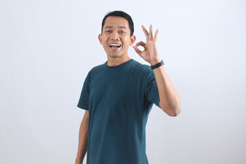 Happy Asian man showing OK gesture for approval and success