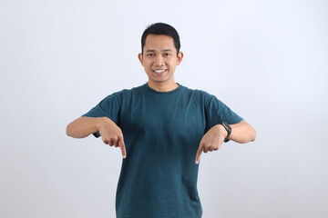 Smiling Asian man pointing fingers down at copy space