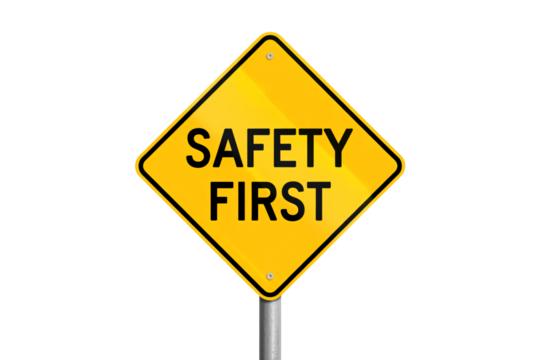 Bright yellow 'Safety First' warning sign on pole