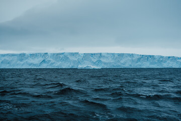 An aerial perspective showcases the dramatic melting icebergs of Antarctica, where the vivid blue...