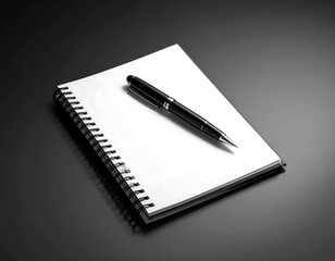 Spiral-bound notebook and sleek pen resting on a dark gray surface