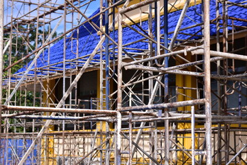 Scaffolding for building repair, A construction worker assembling scaffolding around  