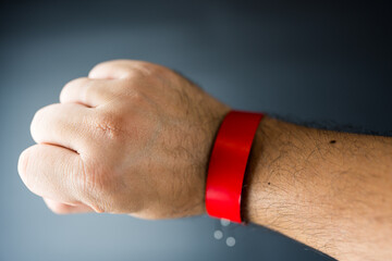 Close up of a red paper event bracelet on a male wrist, mockup template for an event.