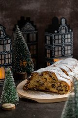 Traditional German Christmas stollen cake in background of handmade festive decor. Winter holiday treats. Vegan baking recipe preparation