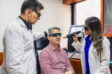 Derma clinic professionals doing cosmetic laser skin treatment