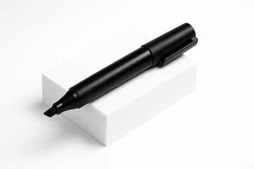 Black marker with cap on placed diagonally on a matte white acrylic block studio isolated on pure white