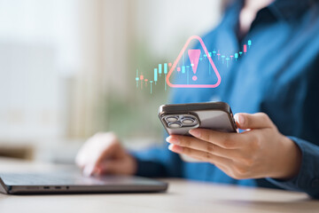 risk, volatility, market, investment, warning, alert, decline, analysis, Business person checking smartphone with market alert icon representing risk, volatility, and investment warning.