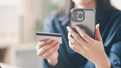 credit, card, payment, ecommerce, transaction, Close-up of a woman using a smartphone and holding a credit card for online payment, representing digital banking, ecommerce, and secure transaction.