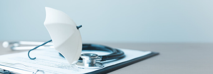 health, insurance, medical, policy, coverage, hospital, A stethoscope and umbrella on health insurance documents represent protection, healthcare coverage, and medical safety concepts. © Garun Studios