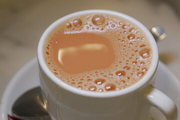 Warm cup of milk tea on a table