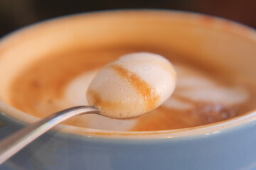 Beautiful foam art on a coffee cup with spoon detail