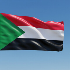 The flag of Sudan waving in the wind against a clear blue sky.