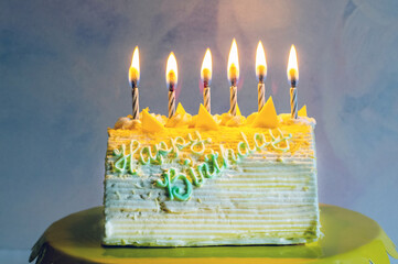  Lemon torte birthday cake with candles si ready to be enjoyed at a party