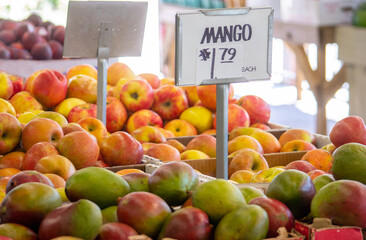 Mangoes and apples for sale at a farm market
