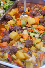 Hearty vegetable stew with meatballs in a serving tray