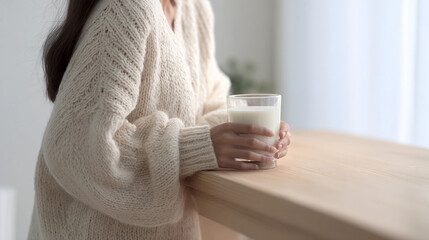 Asian Woman in Cream Oversized Sweater Holding a Glass of White Milk, Generative AI