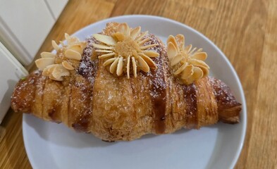 Breakfast with Almond croissant which is a type of flaky, crescent-shaped pastry.
