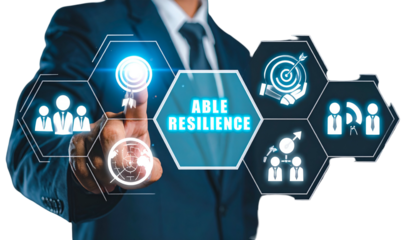 Businessman points at digital "Able Resilience" interface, with icons of teamwork, goals