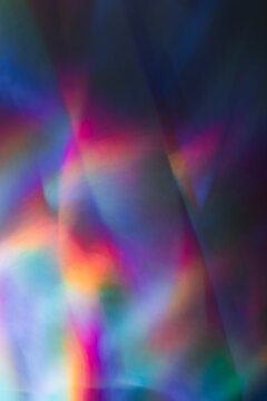 Soft colorful abstract background with blurred light reflections in purple, blue, and pink tones, creating a dreamy gradient texture.
