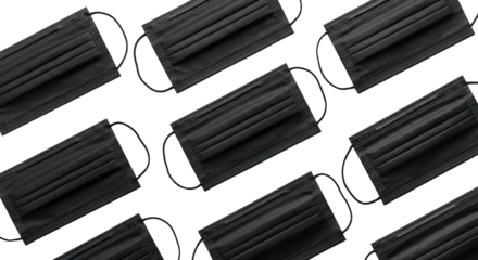 Pattern of black face masks on a dark background, angled view
