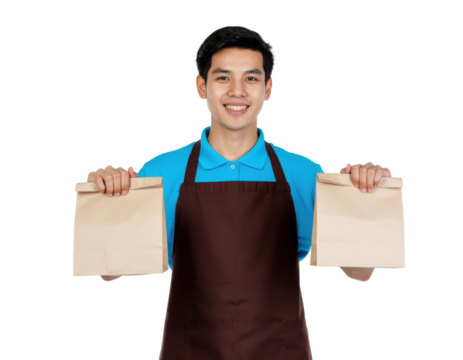 A smiling young man in an apron holds two takeaway bags, showcasing a cheerful demeanor and readiness for food delivery.