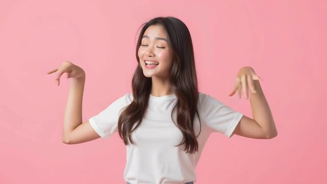 Young woman with long hair in casual white t shirt smiling happily with open arms and hands on pink background showing excitement and joy