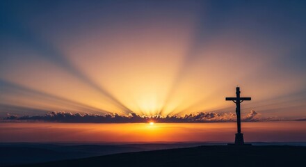 Silhouette of cross on hilltop, illuminated by sunburst sunset