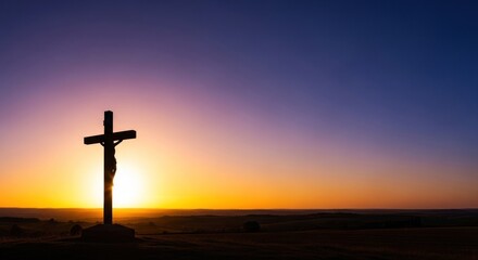 Silhouetted cross against colorful sunset sky over rolling hills