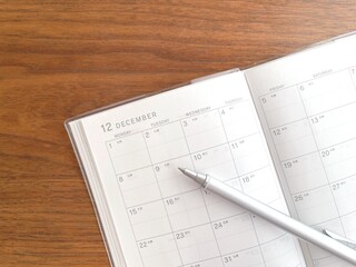 December schedule book open on a wooden table