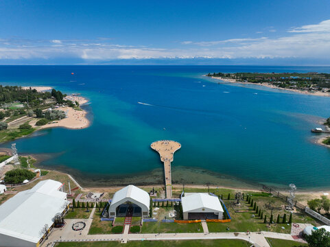 Aerial top down view of the wooden pier shaped like a Komuz, a traditional Kyrgyz instrument, at the Rukh Ordo Cultural Center on Issyk-Kul Lake