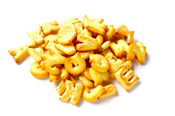 A pile of alphabet-shaped butter cookies arranged on a white background.