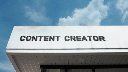 Content Creator word sign displayed on the exterior of a modern building under a clear blue sky, symbolizing digital media, creativity, online publishing, social media, and multimedia production