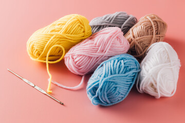 Colorful Yarn Bundles with Crochet Hook on Soft Pink Background