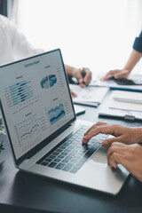 Business data analysis concept with colleagues reviewing financial report on laptop, pointing at...