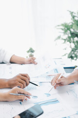 Business teamwork reviewing financial report with charts and graphs in modern office, colleagues discussing analysis, planning strategy, growth and corporate success with documents and technology.