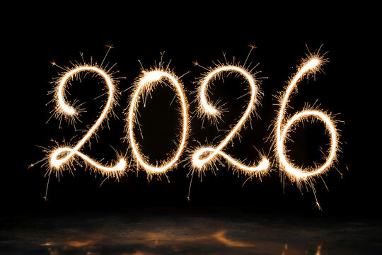 Bright sparkler fireworks spell out the year 2026 against a dark background