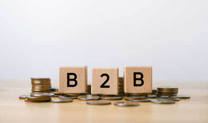 business to business with wooden blocks with B2B symbols placed on stack of coins, commercial marketing.