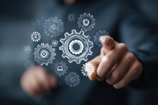 A person's hand pointing towards a collection of interconnected gears, symbolizing technology and innovation.