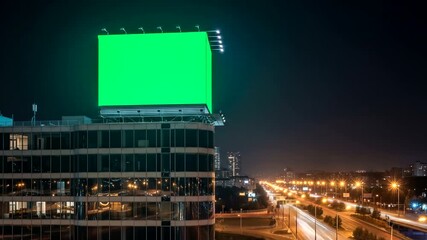 Billboard mockup on building rooftop with green screen at night with city traffic long exposure